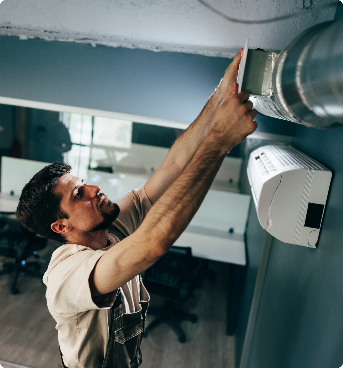 Worker adjusting ceiling air duct