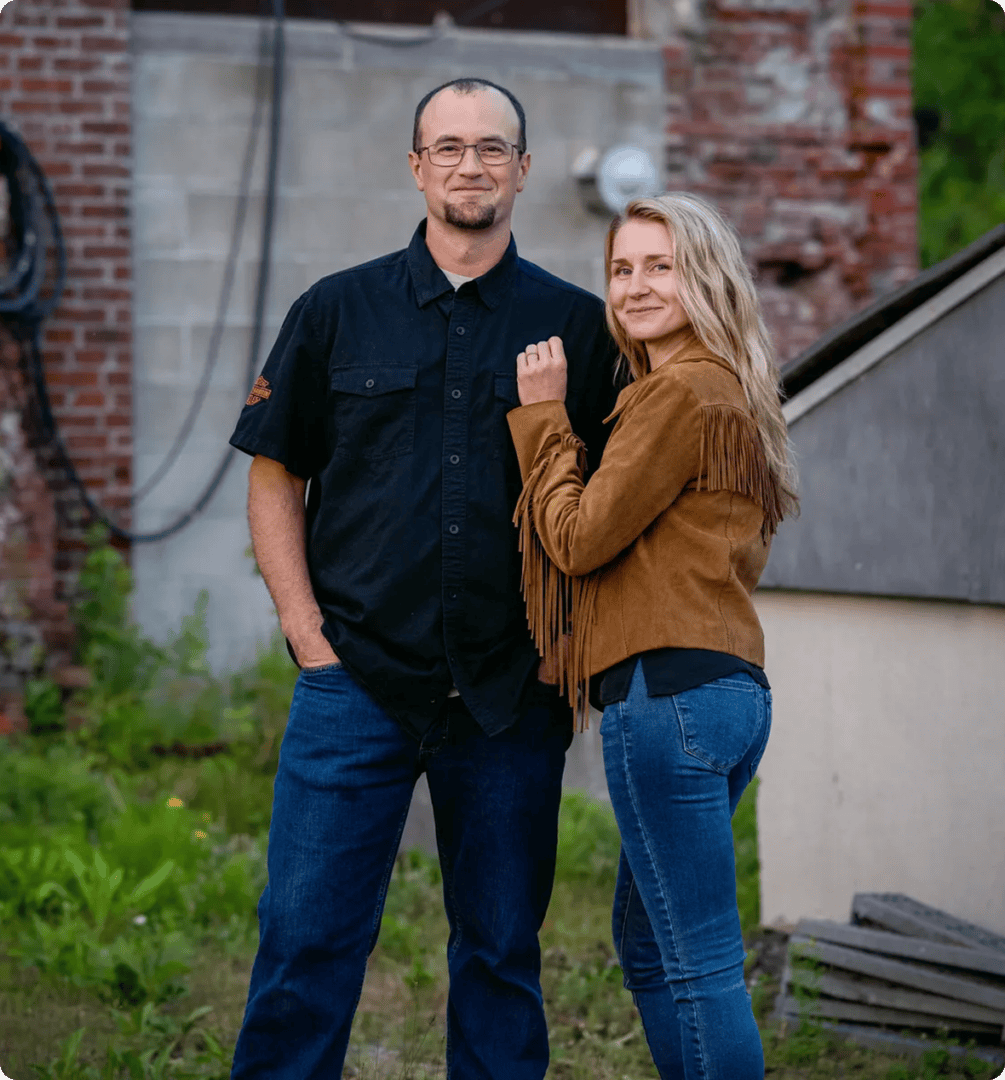 Couple smiling outdoors by brick wall